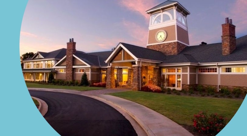 Clubhouse and clock tower at dusk at Village at Deaton Creek, a 55+ community in Hoschton, Georgia.