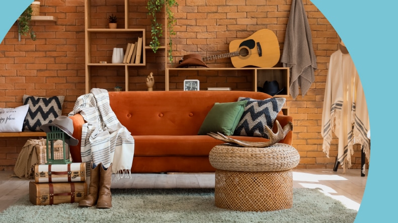 Interior of a living room with a sofa, a shelf unit, and cowboy hats.