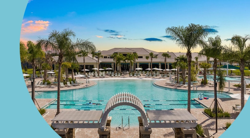 Palm trees and lounge chairs surrounding the outdoor pool at Del Webb Sunbridge, a 55+ community in St. Cloud, Florida.