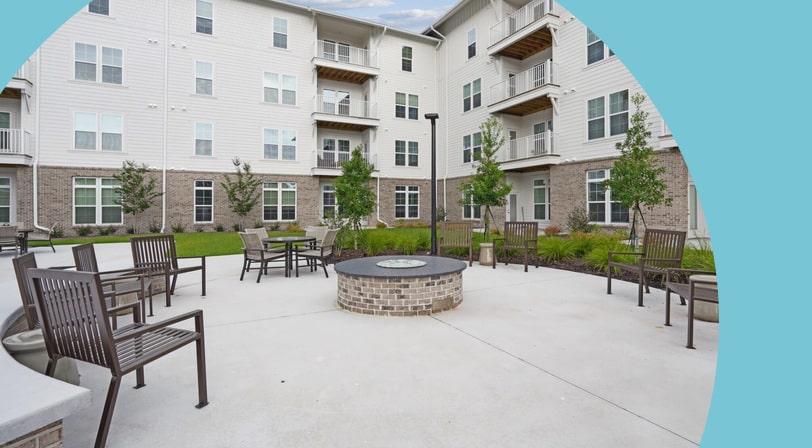 An outdoor lounge area beside a firepit at The Leo Myrtle Beach, a 55+ rental community in Myrtle Beach, South Carolina.