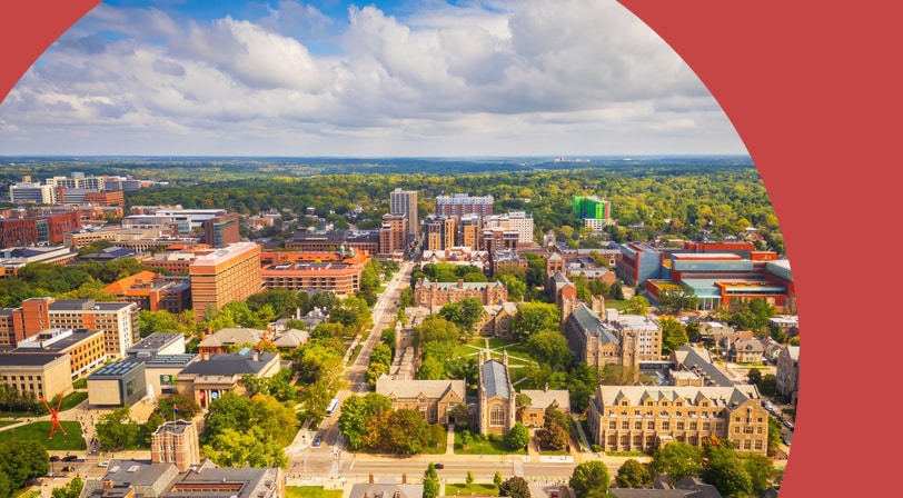 Aerial view of Ann Arbor, Michigan, showing the University of Michigan campus, its central quad, and the surrounding tree-filled neighborhoods.