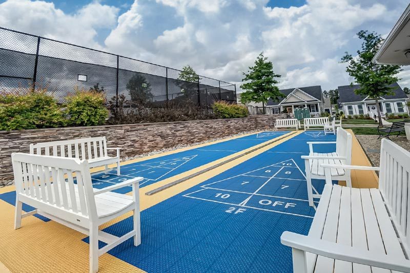 bailey’s-glen-cornelius-north-carolina Benches beside the outdoor shuffleboard courts at Bailey's Glen, a 55+ community in Cornelius, North Carolina.