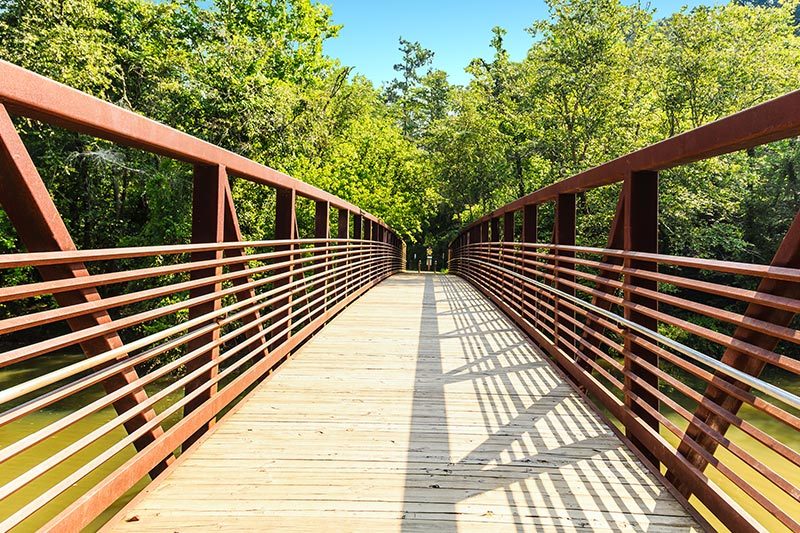 A steel and concrete bridge over the Little River in Woodstock Georgia Park.