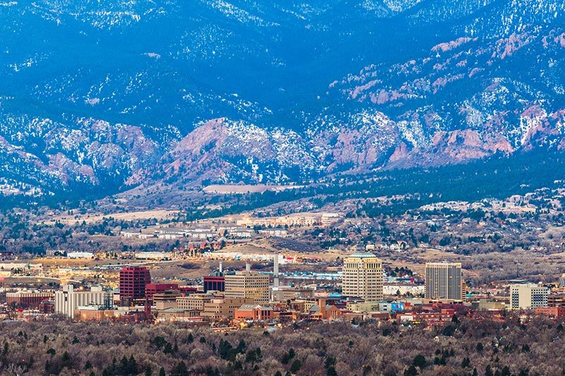 The downtown skyline and mountains at dusk in Colorado Springs, Colorado.