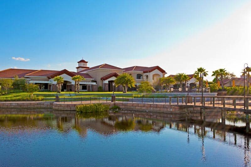 View across a pond of the clubhouse at Del Webb Orlando, a 55+ community in Davenport, Florida