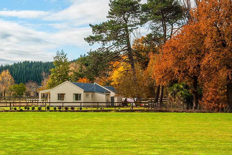 A farm house surrounded by trees in a rural area.