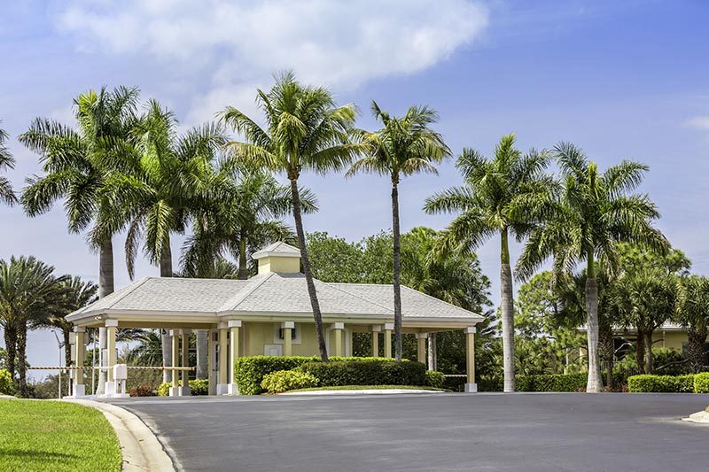 Palm trees surrounding the entrance to a gated community in Naples, Florida.