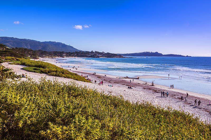 People enjoying Carmel Sunset Beach at Carmel by the Sea, California.