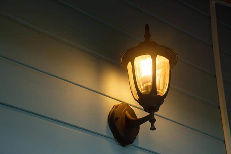 An outdoor sconce on the side of a house in a 55+ community.
