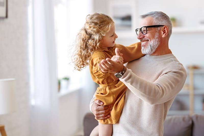 A loving caring grandfather looking at his cute little granddaughter.