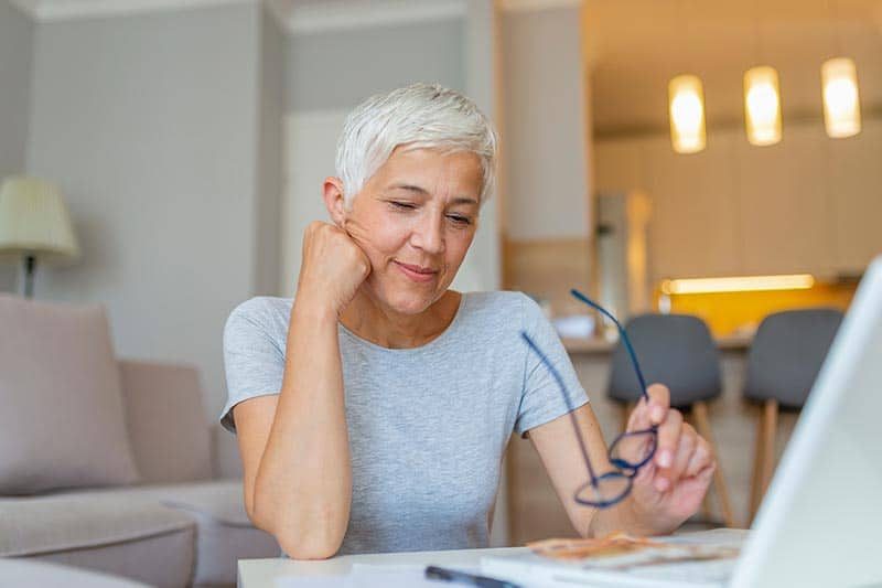 A mature woman checking bills at home.