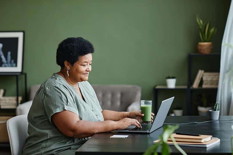 mature-woman-using-laptop-and-smiling