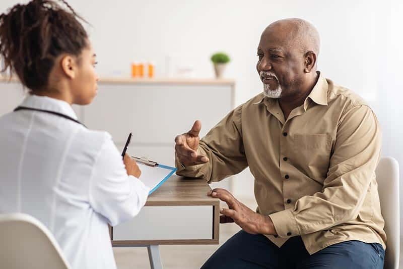 A senior man visiting a doctor and discussing health issues.