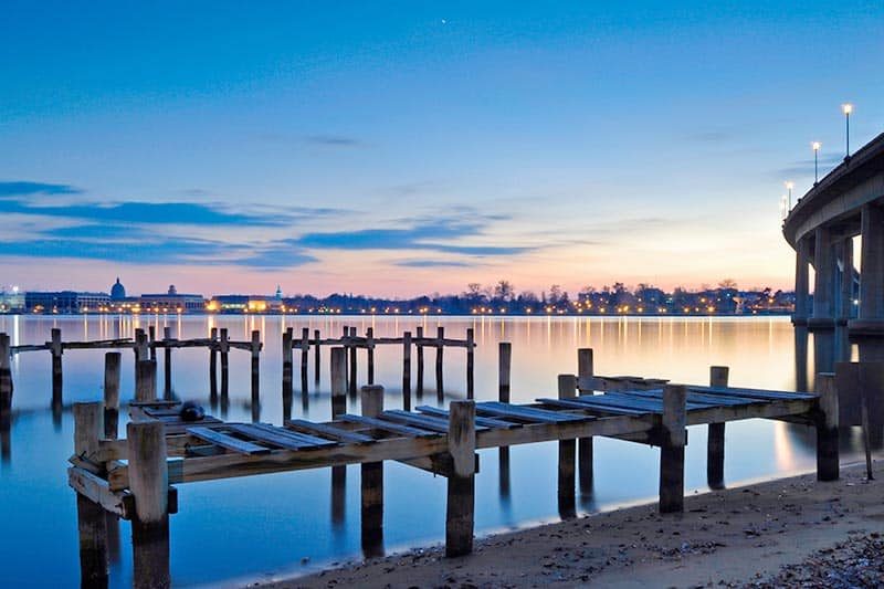 Old wooden piers stand empty in the still waters of the Severn River at twilight.