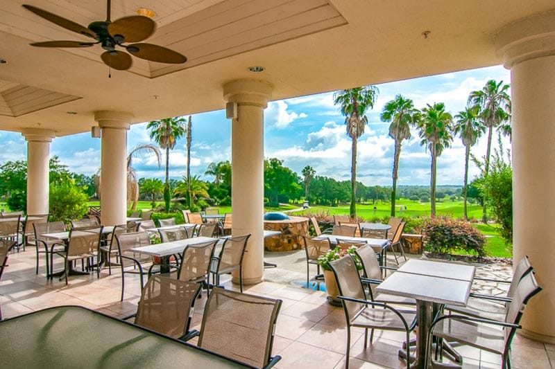 Tables and chairs on the outdoor patio at Spruce Creek Country Club in Summerfield, Florida.