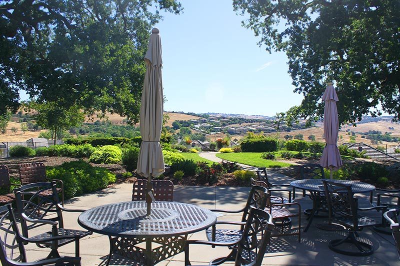 Outdoor tables and chairs overlooking the grounds of Versante in El Dorado Hills, California