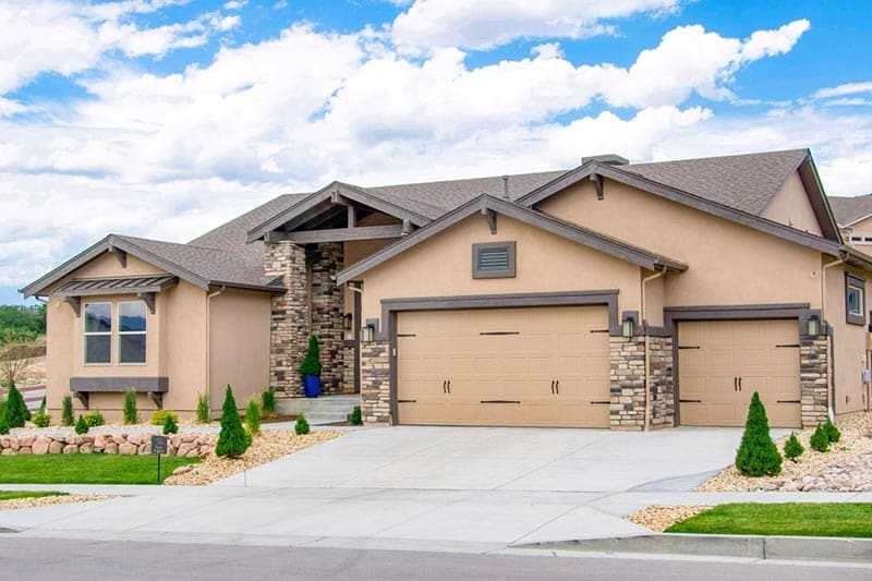 Exterior view of a home on a sunny day at Village of Cortona in Colorado Springs, Colorado.