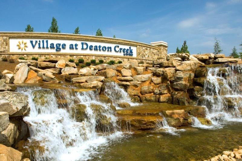 A water feature beside the welcome sign at the entrance of Village at Deaton Creek, 55+ community in Hoschton, Georgia.